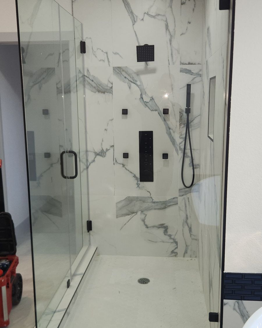 Frameless glass shower with marble slab walls